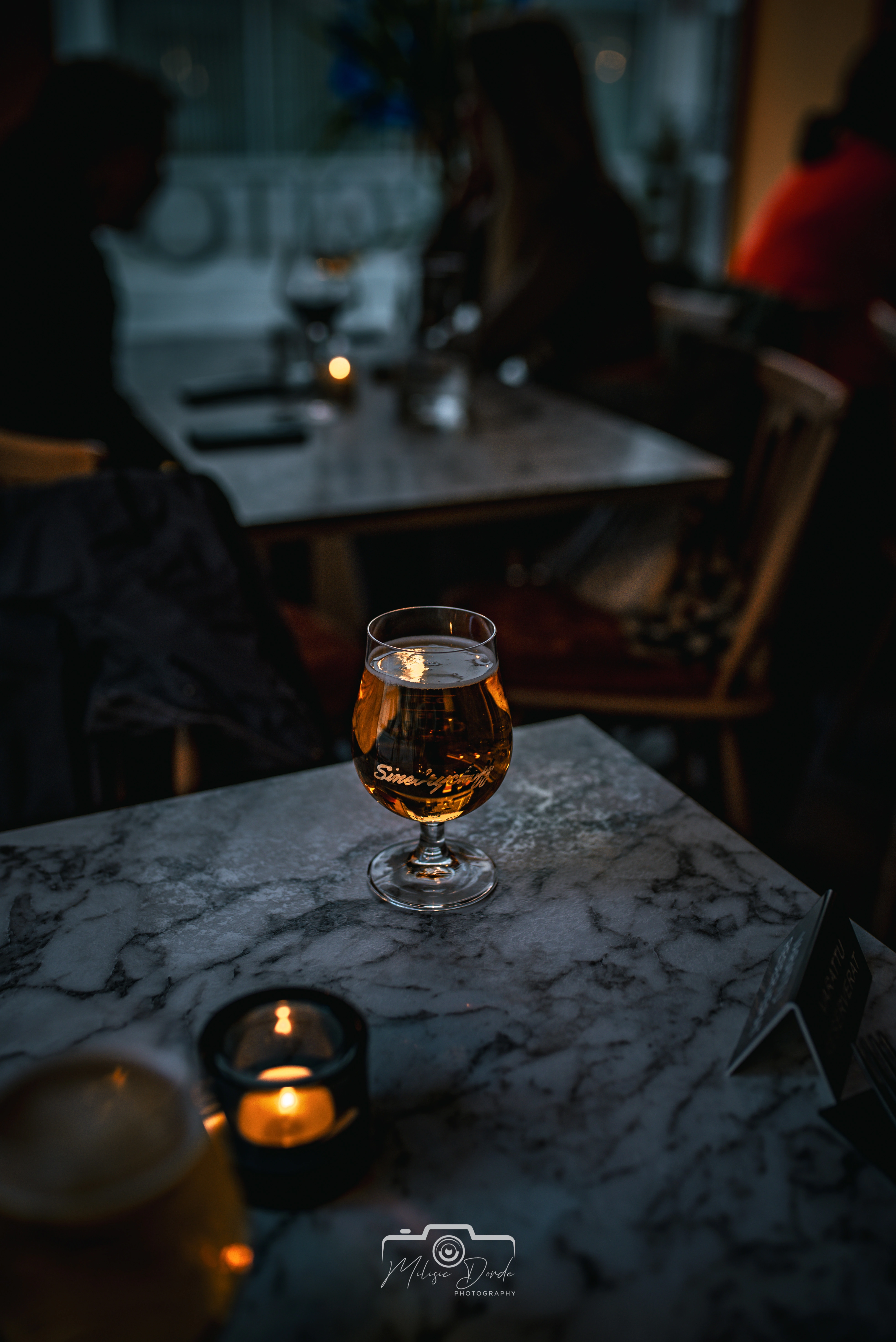 A toast to the evening: Enjoying a crisp drink in the warm, candlelit ambiance of El Barcito. Image